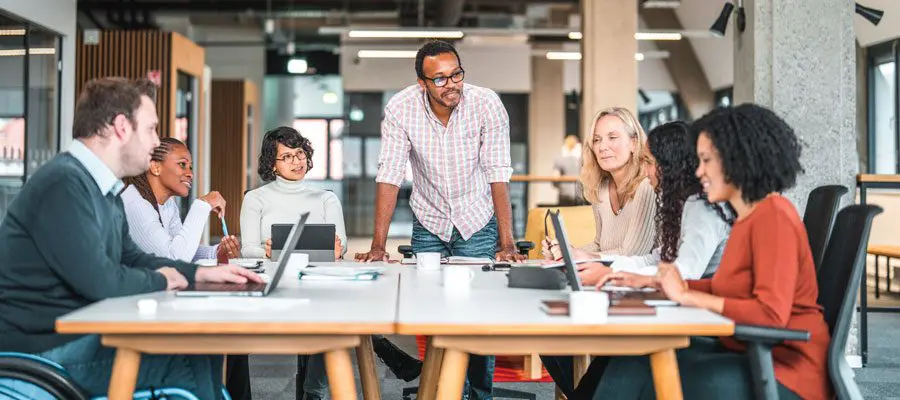 Coworkers collaborating in an open-plan office setting.