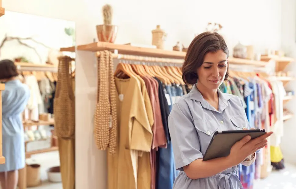 Woman managing retail inventory with clipboard.