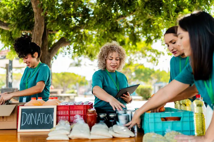 Mature woman organizing donation boxes outdoors
