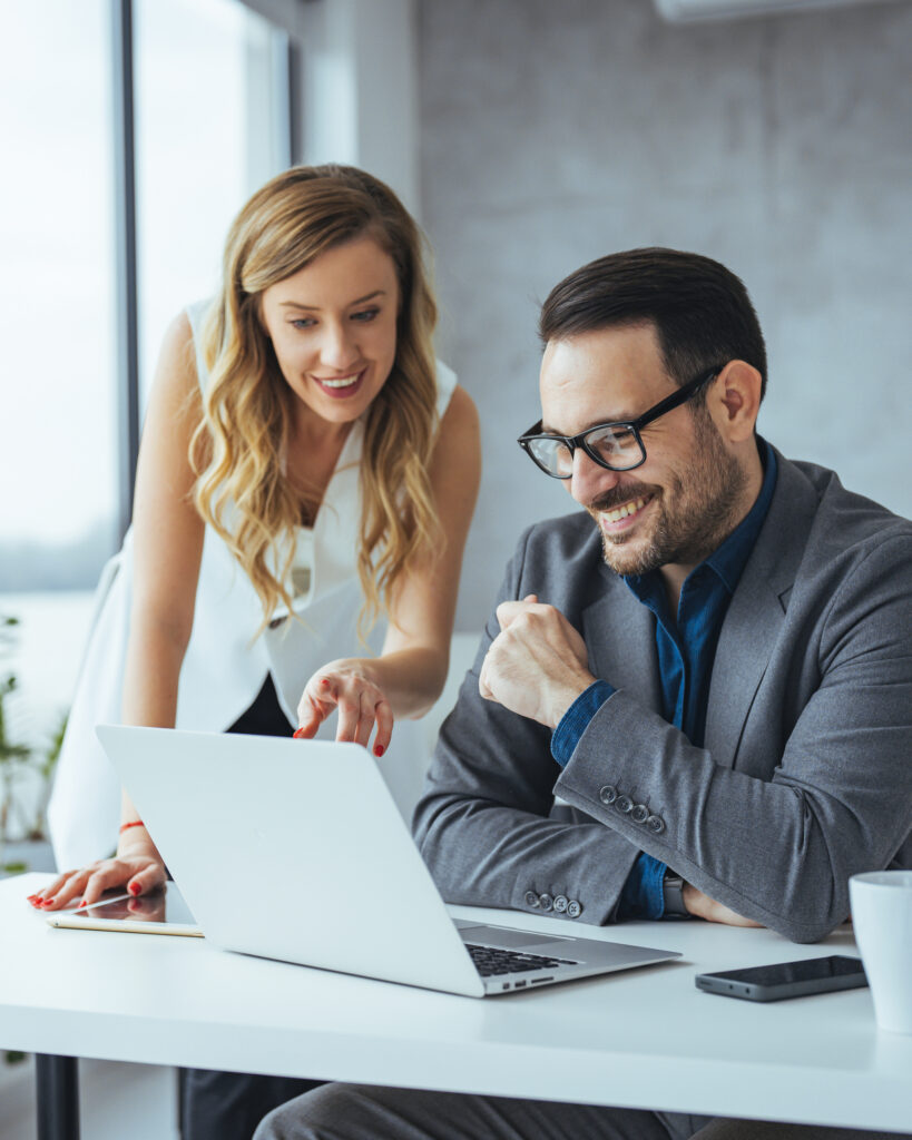 Colleagues Collaborating on Project with Laptop in Office Environment